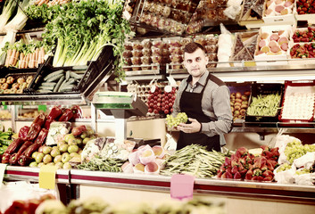 Male shop assistant is weighing grapes