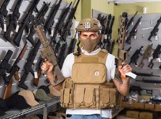man in army uniform with weapon in military market