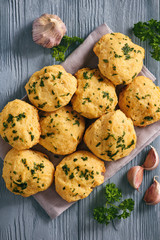 Homemade garlic cheese biscuits on wooden background.