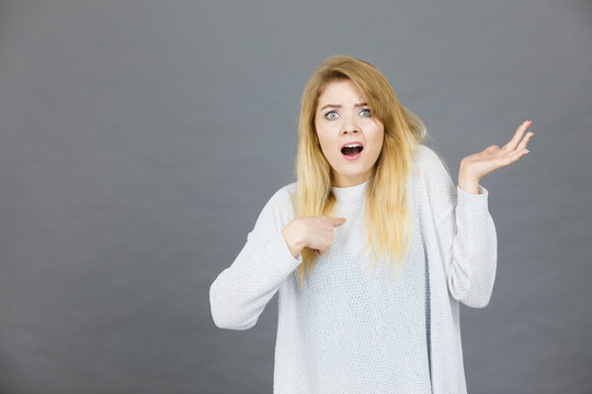 Confused young blonde woman gesturing with hands