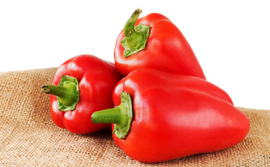 Sweet red peppers on burlap and white background