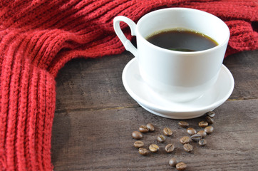 cup of coffee with grains, red burgundy scarf, wooden, winter concept, hot drink, snowflakes on dark background