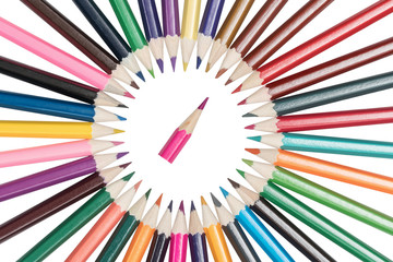 Pencils arranged in a circle and pointing to the center on a small pencil isolated on a white background