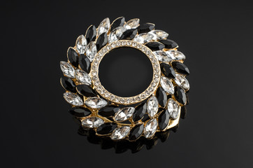 round brooch with gems isolated on black