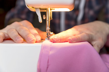 Tailoring Process - Women's hands behind her sewing machine