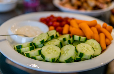 Vegetables and dip on a white round plate