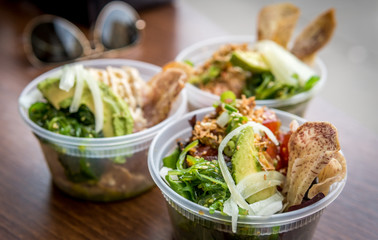 Three bowls of Poke in plastic bowls