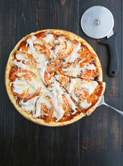 fresh and delicious Italian pizza on a wooden table and a pizza knife