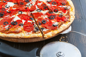 fresh and delicious Italian pizza on a wooden table and a pizza knife