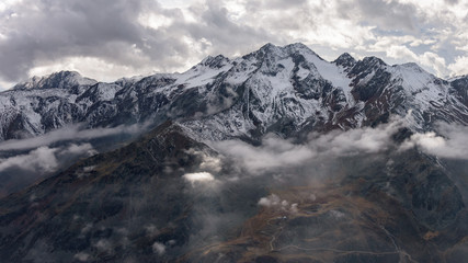 Mountain range with clouds and partial sunlight.