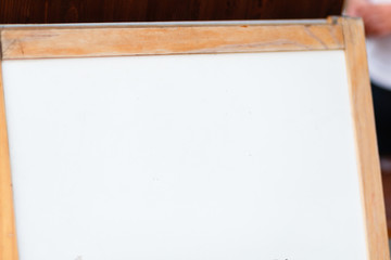 White Board for announcements at the wedding. Blank sign Board with wooden frame on wooden legs before the wedding ceremony. wedding decoration closeup