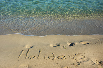 The word holidays written in the sand on a beach
