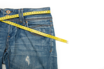 Blue jeans and the measure tape on a white background. Empty space