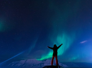 The polar arctic Northern lights aurora borealis sky star in Norway Svalbard man in Longyearbyen...