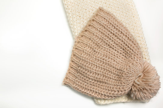Large-knitted hat and white scarf snud on white background.Space for text