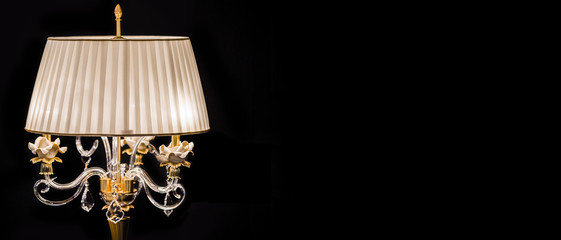 Luxury crystal glass lamp isolated on a black background.  Modern expensive table lamp