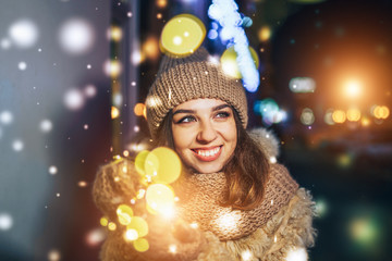 Pretty happy girl hold colorful lights in hands outdoor