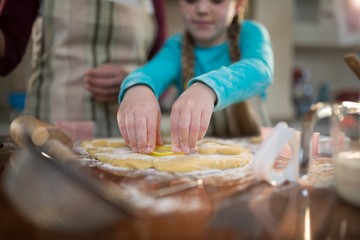 Mother and daughter preparing cookies in kitchen