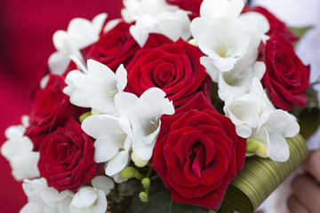 Closeup of beautiful bridal bouquet from white and red flowers