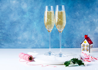 Two glasses with champagne on the table with decorations for Christmas. New Year's style