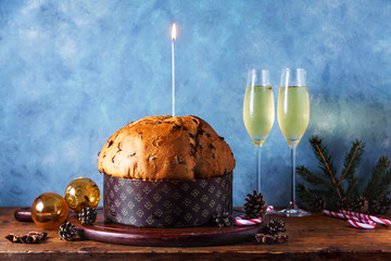 Italian festive bread panetton on a table decorated for Christmas. and two glasses of champagne....