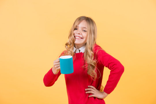 Girl with long blond hair in red sweater hold mug
