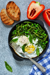 Homemade light breakfast. Scrambled eggs with asparagus and green peas. Crispy baguette grill.