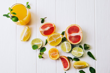 A glass of orange juice with fruits on a white background