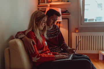 Obraz premium Christmas gifts and happiness between a young couple and a cute dog