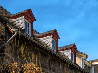 Dachgauben mit roten Holz und Spossenfenster auf Schieferdach