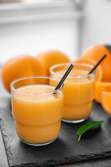 Glasses of fresh orange juice on slate plate
