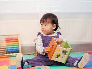 Baby girl play toy at home © M-image