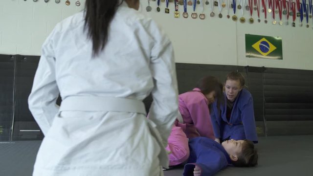 Teenage girls teaching Jiu-jitsu moves for children