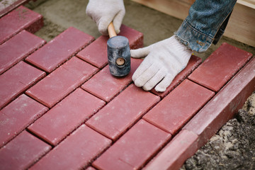 Men paving path using clinker brick