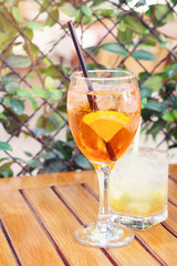 
Spritz and caipirinha coctails, two glasses on the summer terrace of a cafe; selective focus