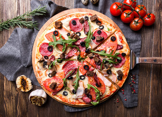 Tasty Italian pizza on a dark wooden background top view - 185185161