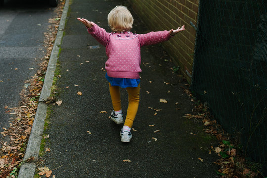 Little girl pretends to be an aeroplane.