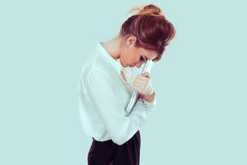 Stressed at work. Unhappy upset sad young woman in side profile bending head on laptop screen...