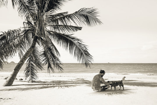 man sitting on the beach near by palm tree