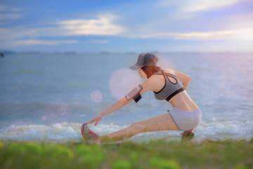 woman relax and feel comfort in exercise practice on the sea beach at light of sunset in back ground