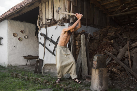 Caucasian man cracking wood logs in a traditional household