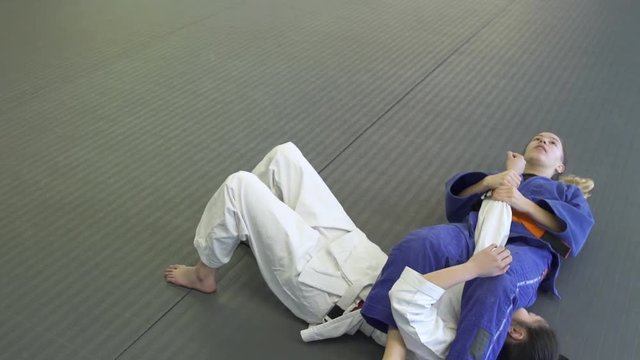 Teenage girls practicing Jiu-jitsu in a dojo
