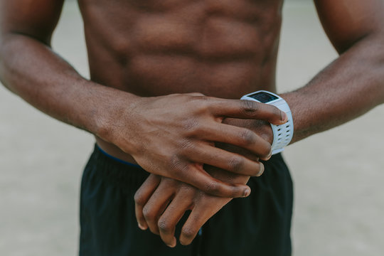 Unrecognizable Black Man Using a Activity Tracker Watch . Close up