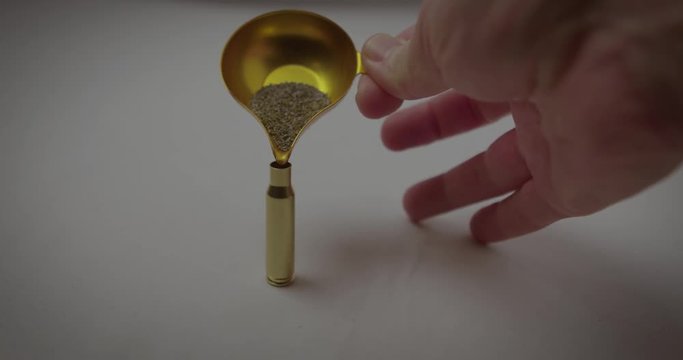 pouring gunpowder into a 308 brass rifle case