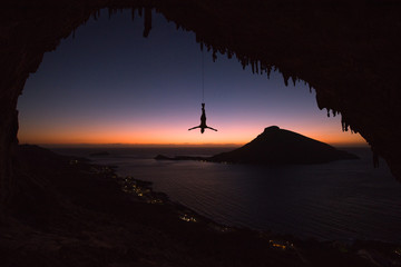 Man hanging upside down from a rope