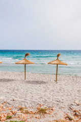 Straw umbrellas on sand beach.
