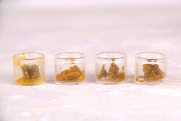 Assorted marijuana extraction concentrate aka wax crumble on jars isolated on white