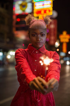 Young woman holding a sparkler firework