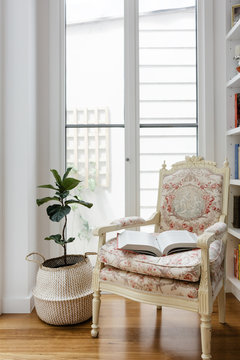 Open book on a comfotable vintage reading chair in a renovated home