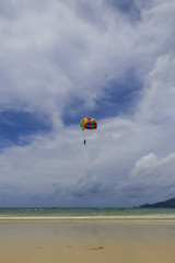 Person parasailing at Patong beach, popular beach in Phuket, Thailand